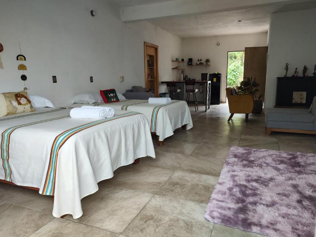 two beds in a room with a living room at departamento huella in Zihuatanejo