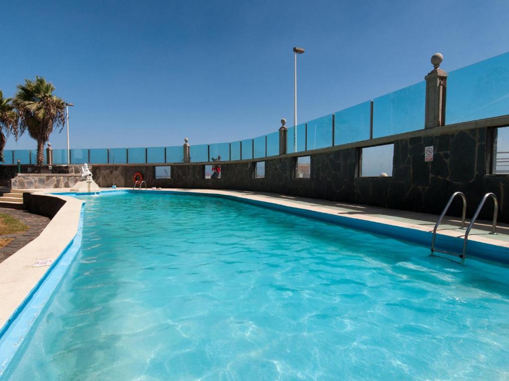 a swimming pool in a building with blue water at Apartment Las Burras Aquarius09 in San Agustin
