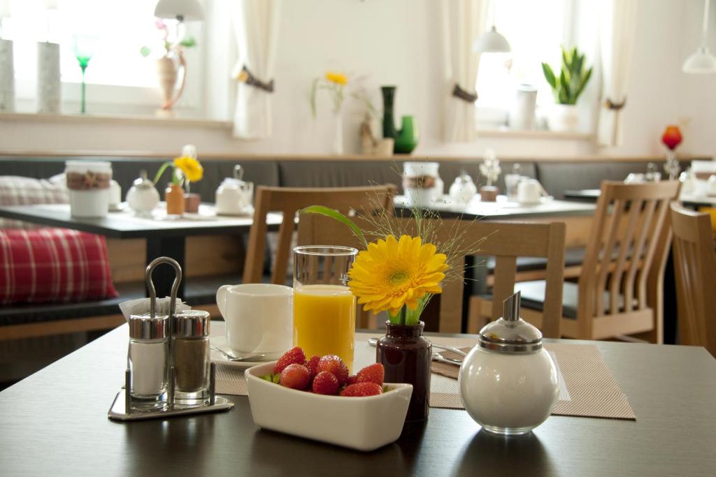 Pension Sperlhof في ايردينغ: طاولة مع وعاء من الفاكهة وكأس من عصير البرتقال