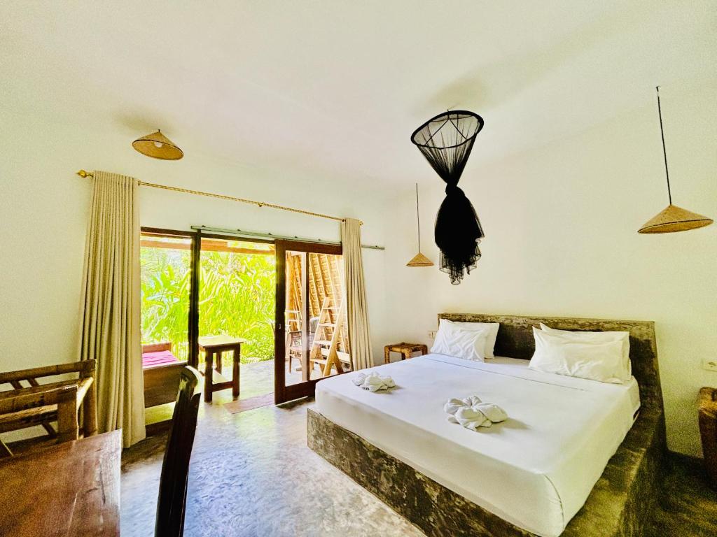 En eller flere senge i et værelse på Ngalung inn bungalow