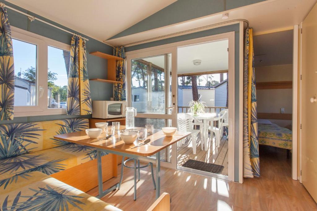 une salle à manger avec une table et un balcon dans l'établissement Résidence Sous les Pins (by Popinns), à Ronce-les-Bains