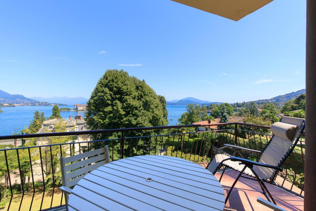 a table and chairs on a balcony with a view of the water at Rampolina view by Impero House in Stresa