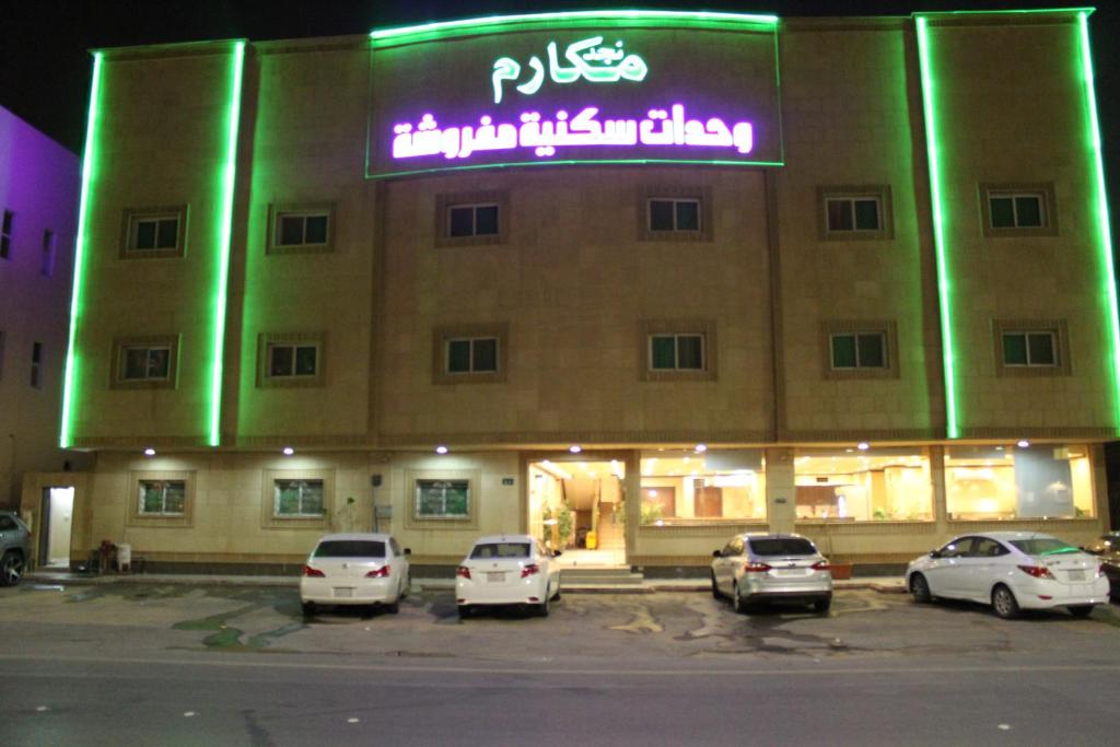 a building with cars parked in a parking lot at Makarim Najd 4 in Riyadh