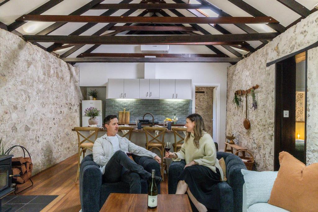 een man en vrouw die in een woonkamer zitten bij Rústica Estate in Quindalup