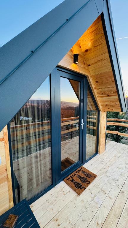 a house with a large window on a deck at Tiny A-Frame Cabin with Private Hot Tub & Views - Perfect for 2 in Şelari