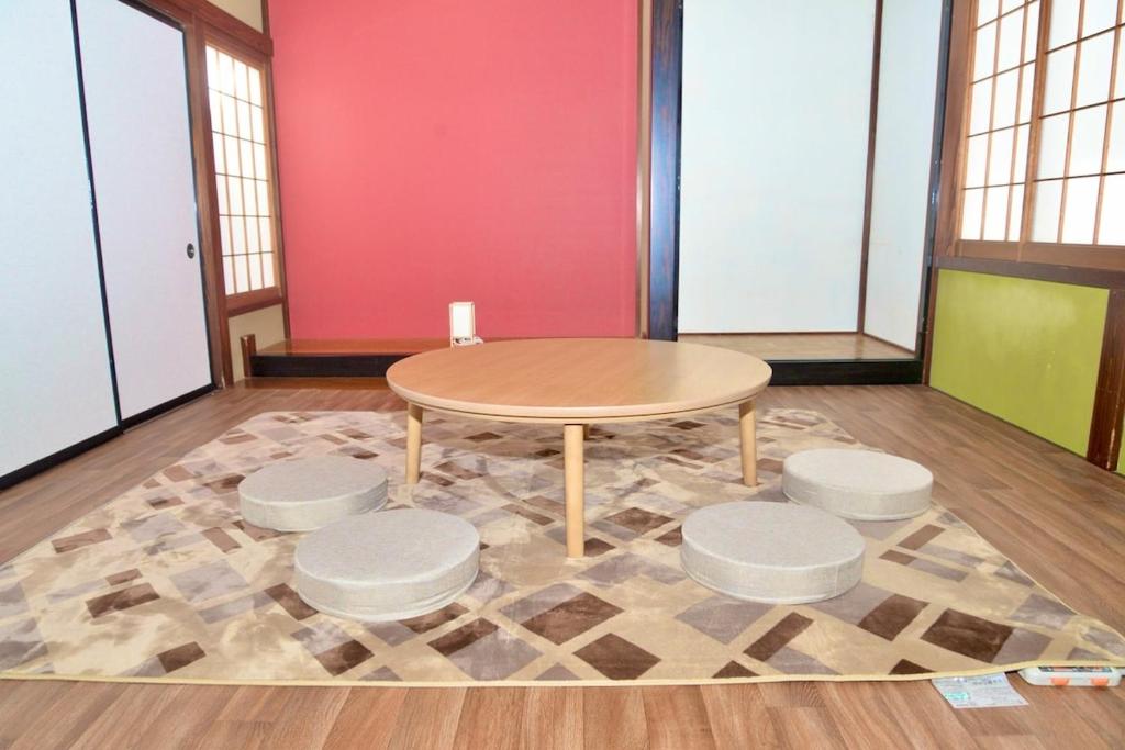 a table and four stools in a room at 高岡ゆるり家 Yururi-Ya in Takaoka