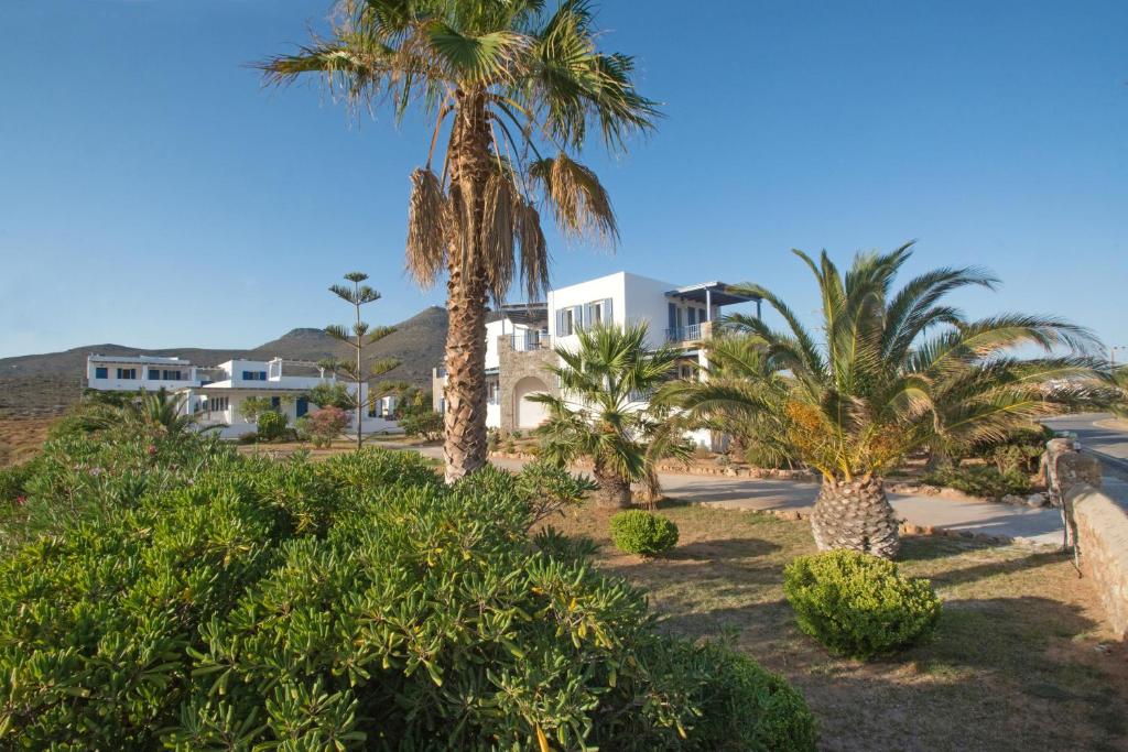 a group of palm trees in front of a house at Anemes in Avlemonas