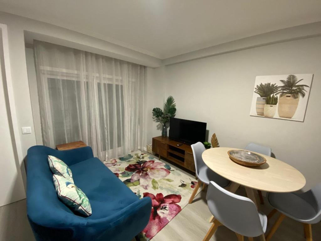 een woonkamer met een blauwe stoel en een tafel bij Aveiro Studio Alboi in Aveiro