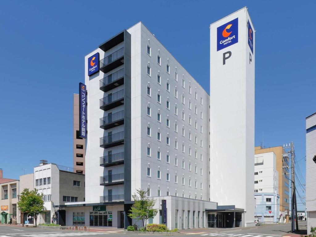 a large white building with a p sign on it at Comfort Hotel Kushiro in Kushiro
