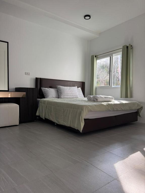 a bedroom with a bed and a window at Woodland Residence in Wok Tum