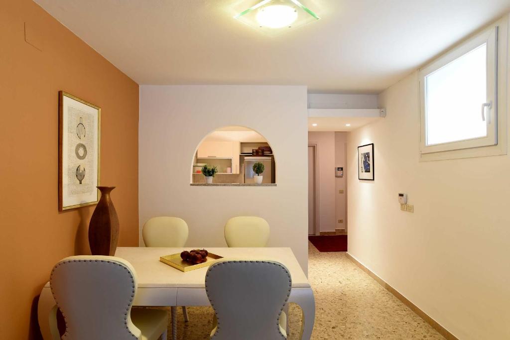 una sala da pranzo con tavolo e sedie bianchi di La Casa di Paolo a Udine
