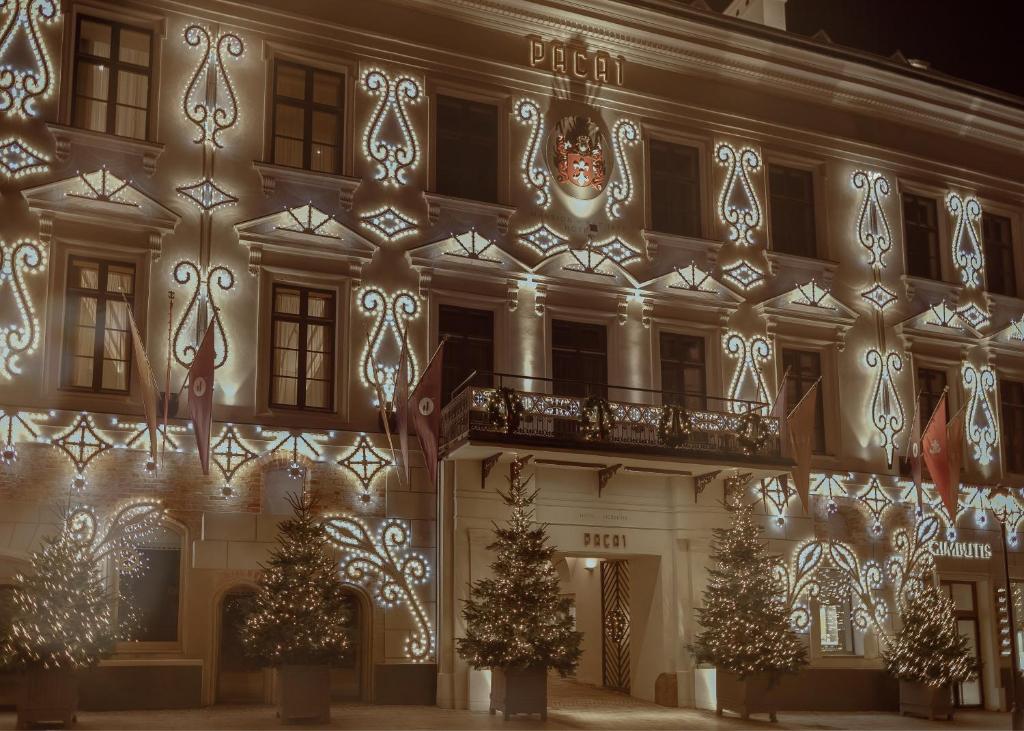 een gebouw versierd voor kerst met kerstbomen en lichtjes bij Hotel Pacai, Vilnius, a Member of Design Hotels in Vilnius