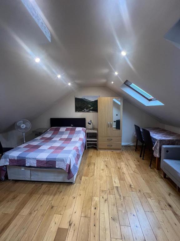 a bedroom with a bed and a table and chairs at Spacious and Modern En-suit in Harrow on the Hill