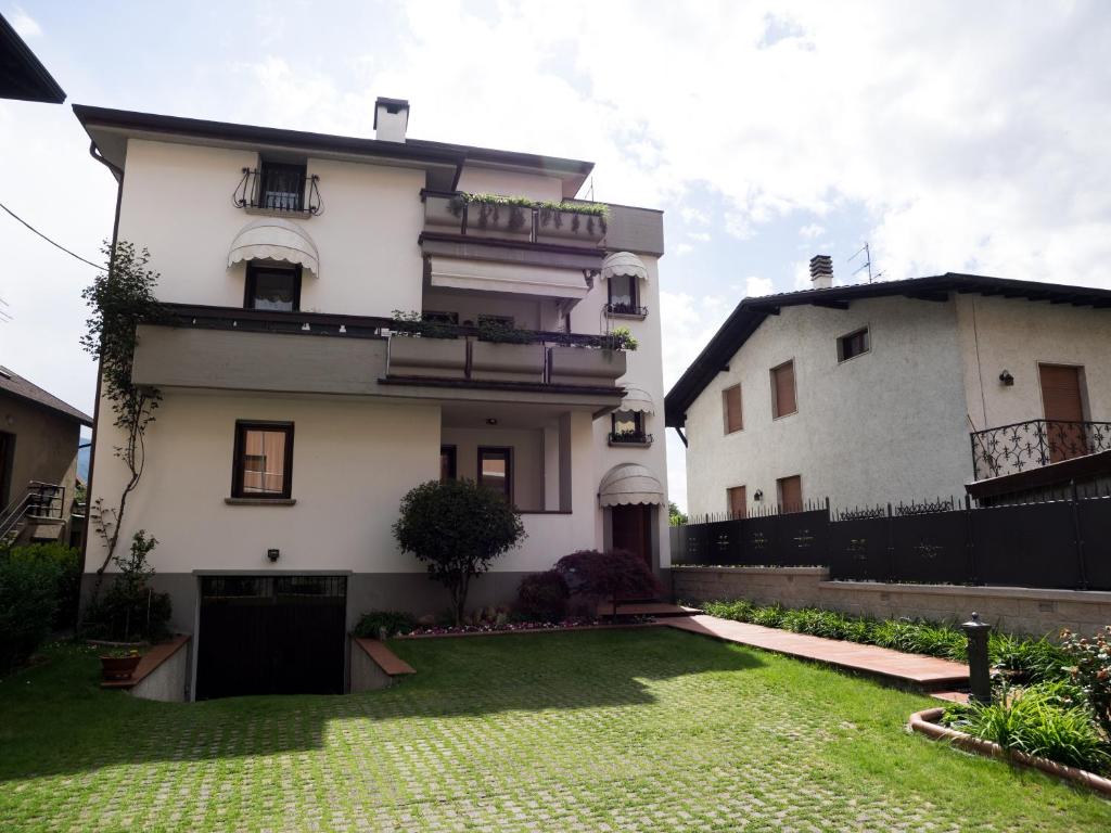 a white house with a yard in front of it at Casa Vacanze Boario in Boario Terme
