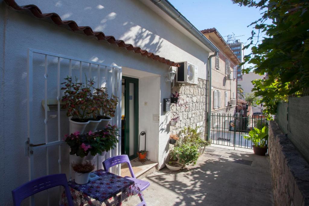 a patio with a purple table and chairs and plants at Apartment Welcome in Split