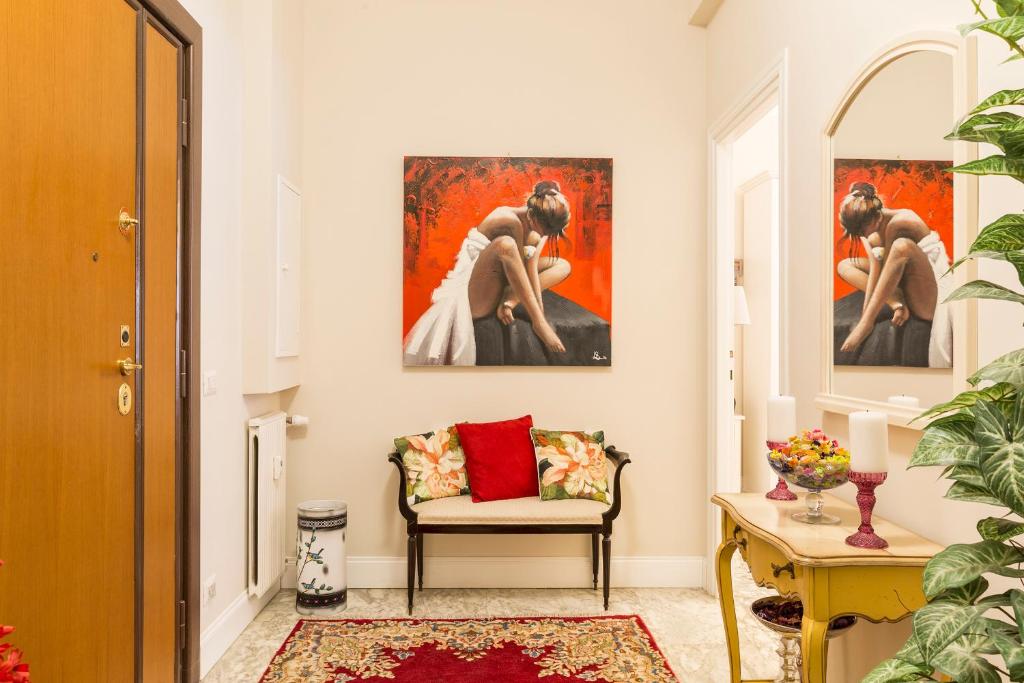 ローマにあるAurora Guest Houseの壁に絵画が2点飾られたリビングルーム
