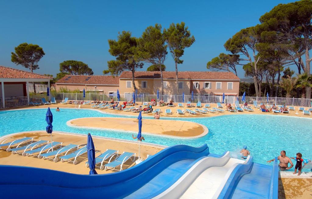 uma grande piscina com escorrega num resort em Résidence Odalys Le Mas des Vignes em Calvisson