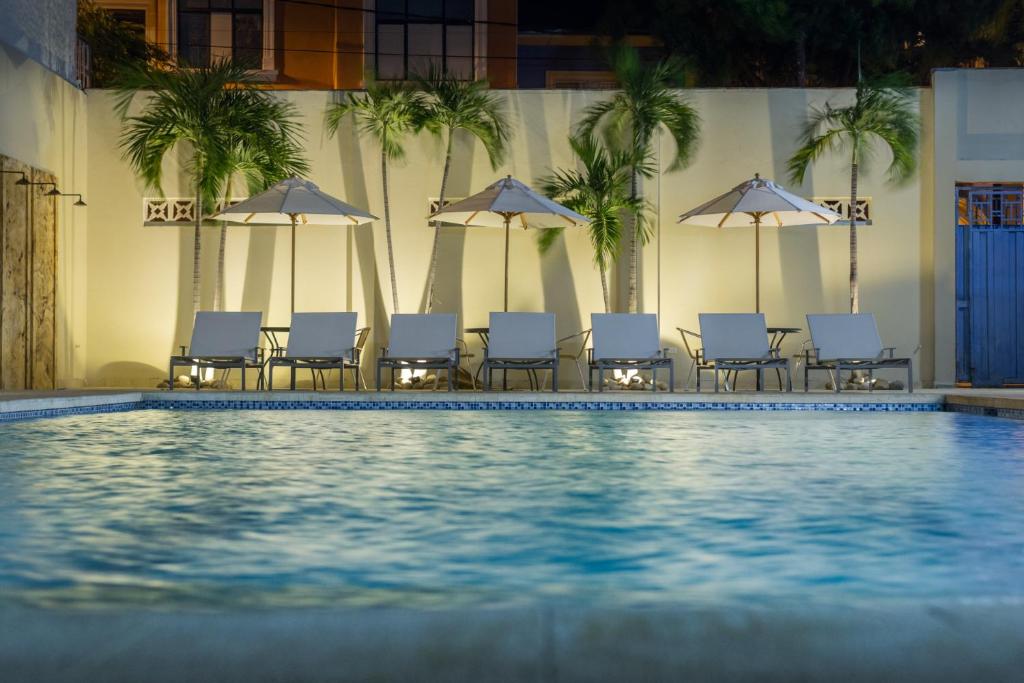 a pool with chairs and umbrellas in a hotel at Hotel San German in Girardot