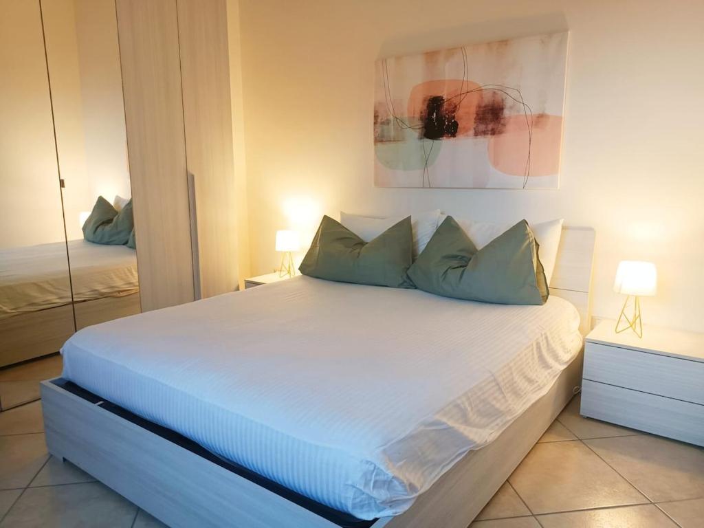 a bedroom with a white bed with blue pillows at Bilocale di Charme in Baronissi
