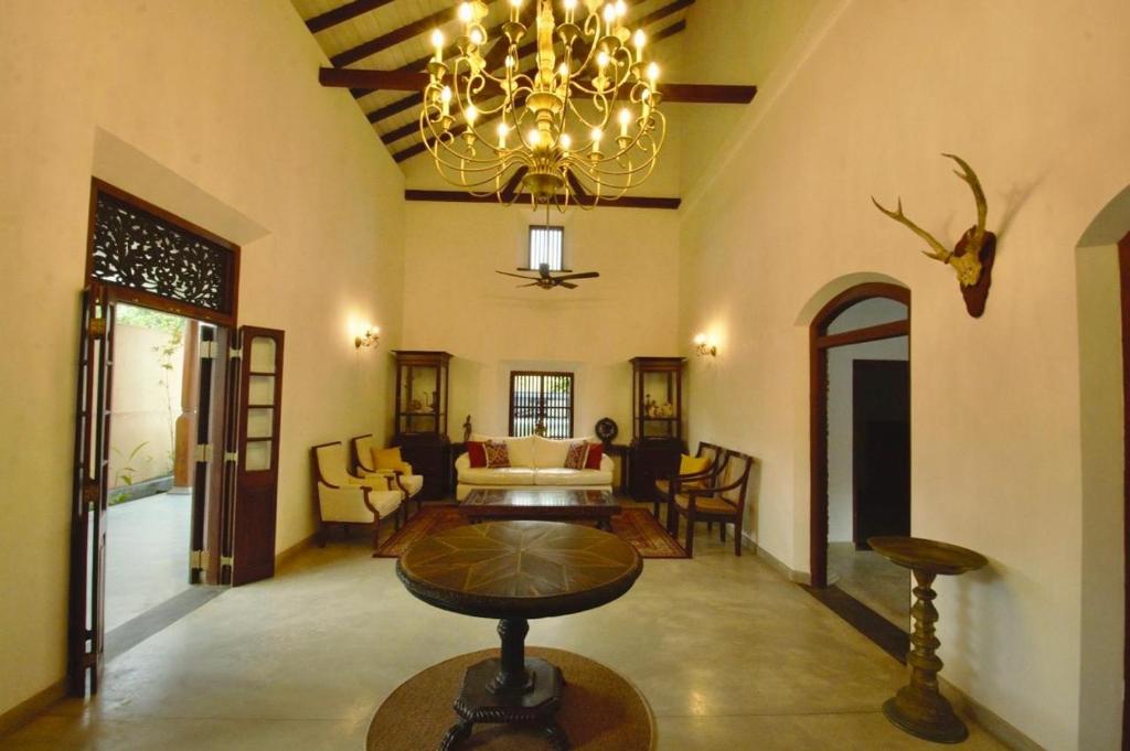 a living room with a table and a chandelier at Agni Luxury Beach Villa in Olagama
