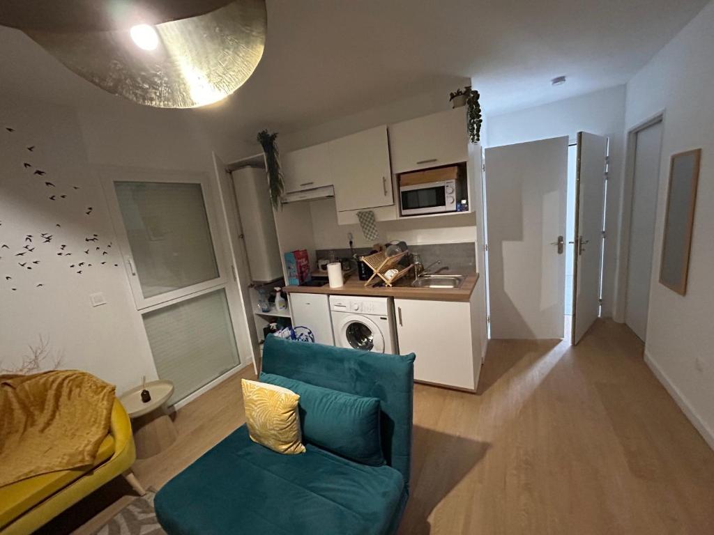 een woonkamer met een blauwe bank en een keuken bij Romantic Victorian guest room calm environment in Gragnague