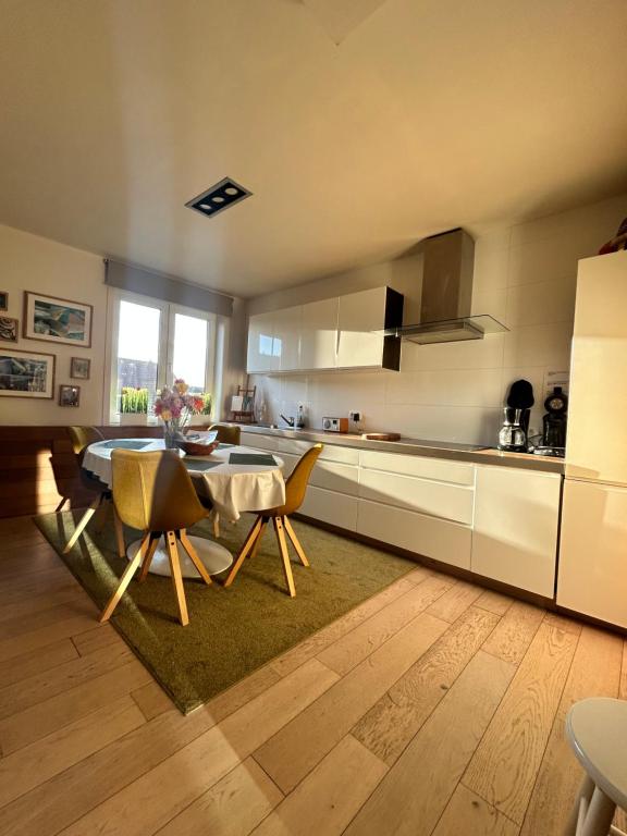 een keuken met een tafel en stoelen in een kamer bij La Mer in De Panne