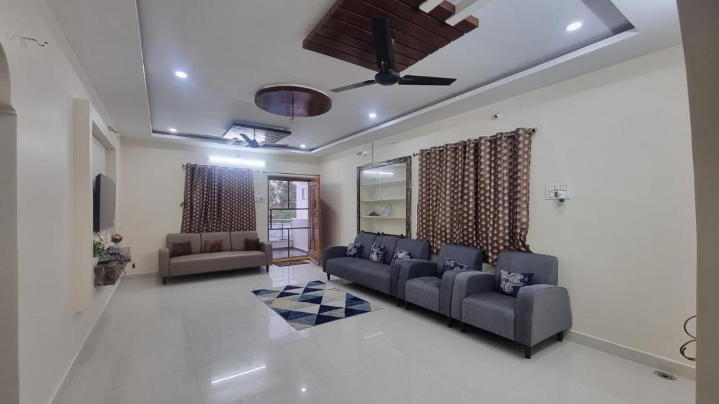 a living room with couches and a ceiling fan at Kutir Stay Aaram in Secunderabad