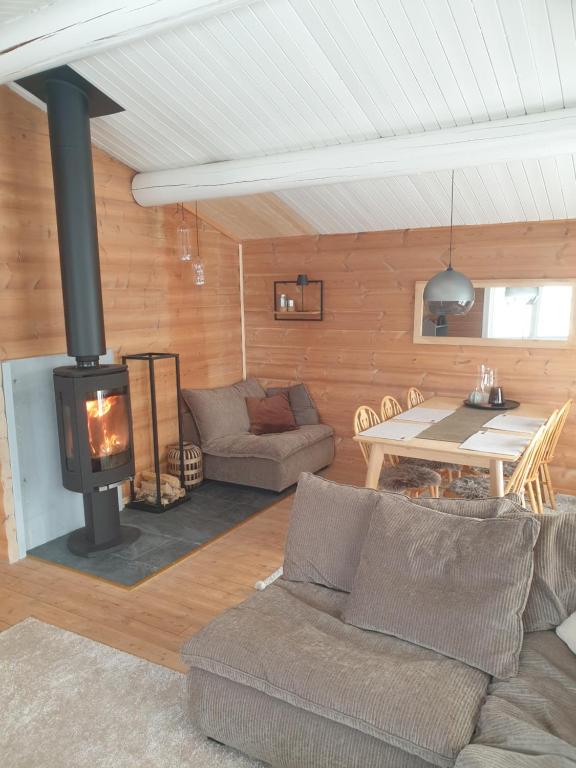 een woonkamer met een bank en een open haard bij Koselig hytte på Beito in Beitostøl