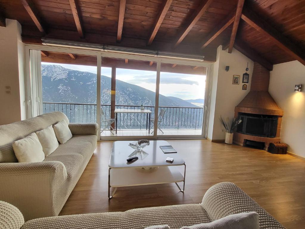 een woonkamer met een bank en een groot raam bij skyview house in Delfoi