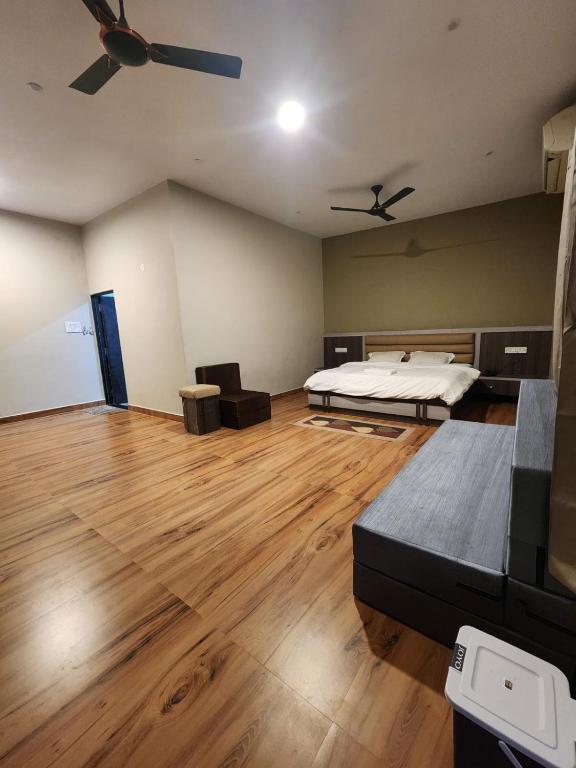 a large room with a bed and wooden floors at Khatiya Camp in Mandlā