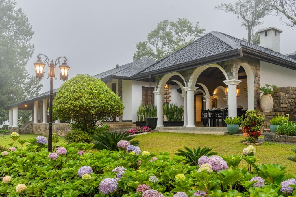 a house with a garden and flowers at Garfield Bungalow by TONIK - 4BR Private Bungalow in Haputale - Mountain Views in Haputale