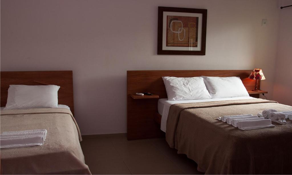 um quarto de hotel com duas camas com toalhas em Pousada Encantos do Peró em Cabo Frio