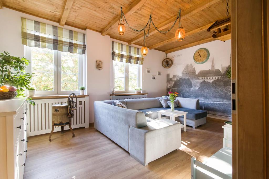 a living room with a blue couch and windows at Apartament Varmia in Olsztyn