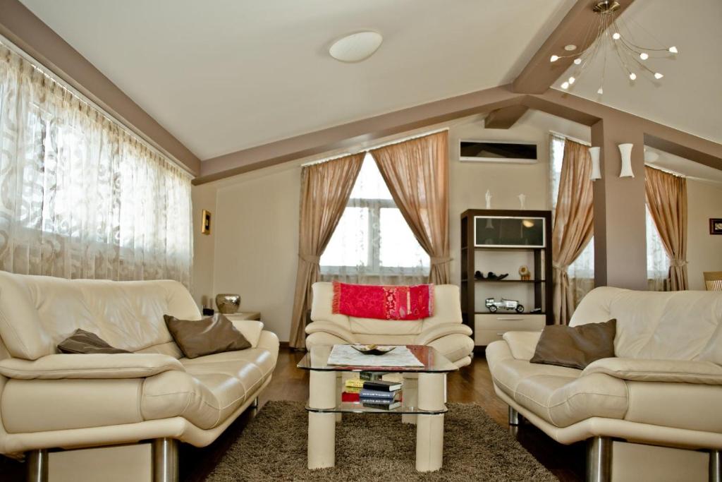 een woonkamer met twee witte stoelen en een tafel bij Apartamento Italia in Međugorje