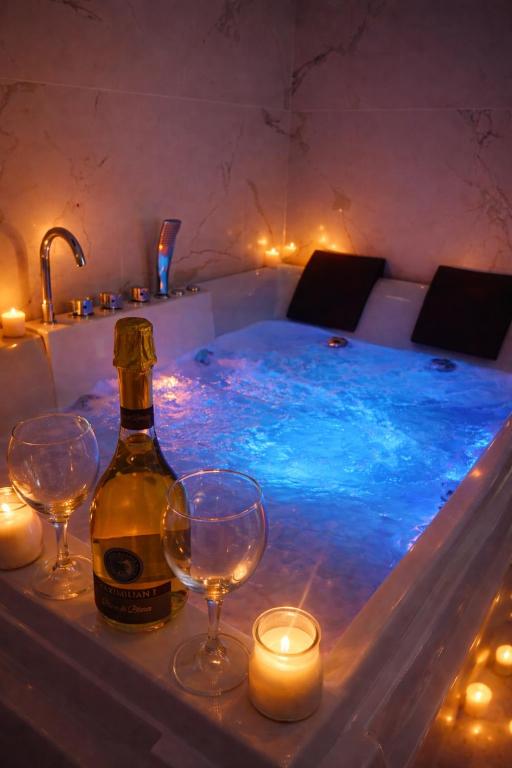 a bottle of wine and two wine glasses in a tub at Nuvola Luxury suite con Idromassaggio Privato & Relax romantico in Turin