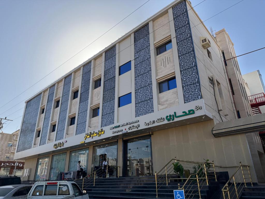 een gebouw met een auto ervoor geparkeerd bij ركن صحاري للشقق المخدومة ضبا Rukn Sahari for Served Apartments in Ḑubā