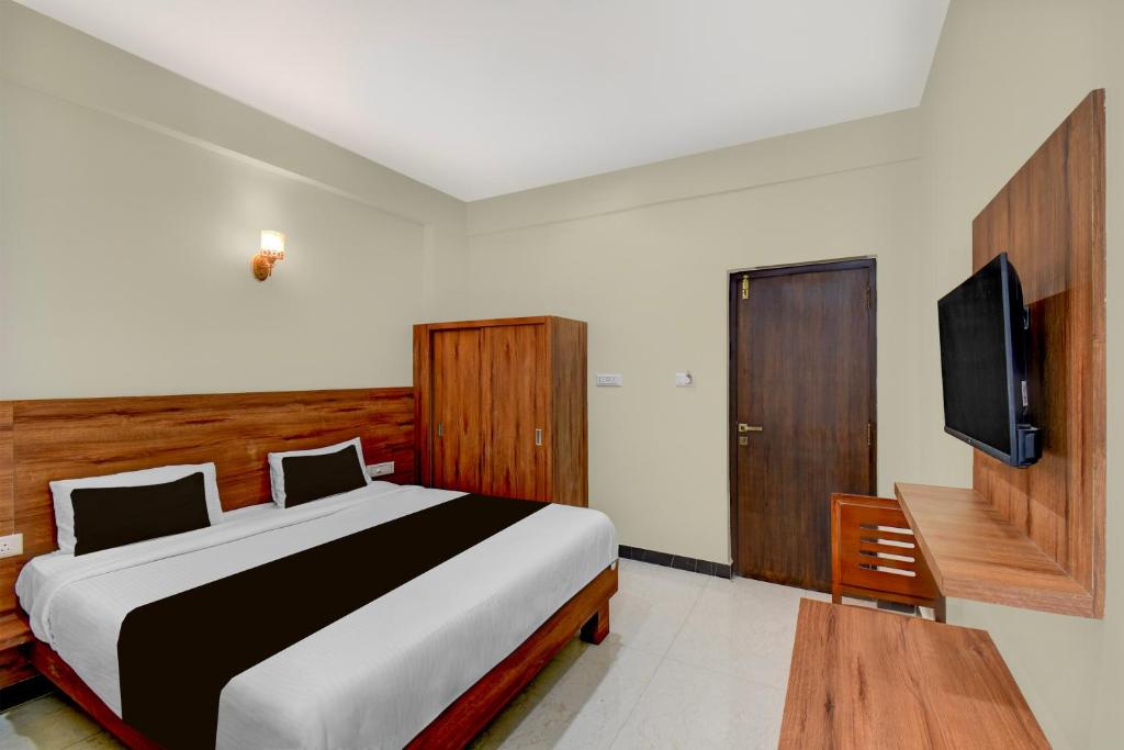 een slaapkamer met een bed en een flatscreen-tv bij Hotel O Royal Stay in Hirisāve