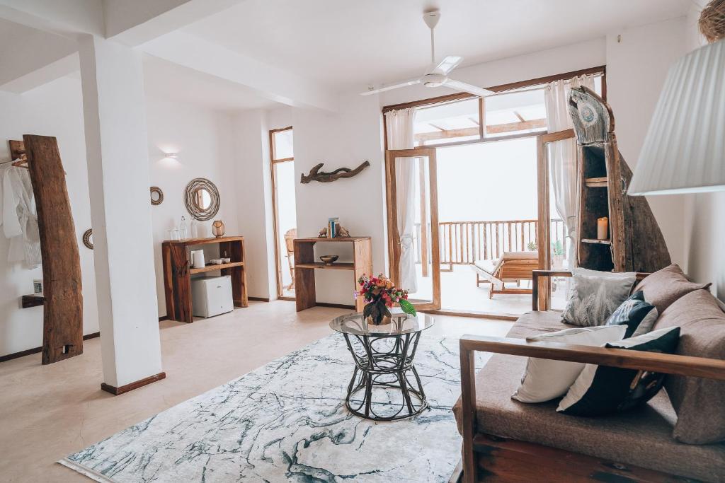 ein Wohnzimmer mit Sofa und Tisch in der Unterkunft ZAN Paradise Jambiani Beach in Makunduchi