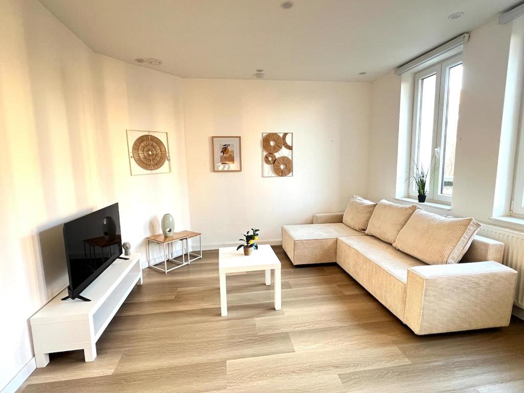 a living room with a couch and a tv at La Petite Escapade-Free Parking in Liège