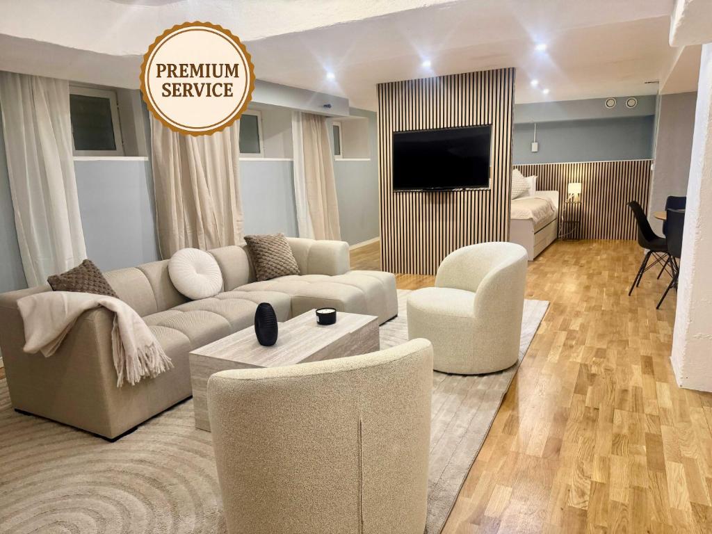 ein Wohnzimmer mit Sofa, Sesseln und Fernseher in der Unterkunft Södermalm City Flat in Stockholm