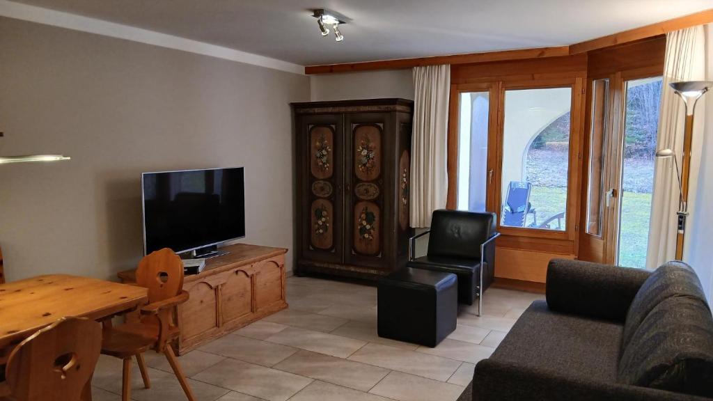 un soggiorno con un divano, una TV e un tavolo di LAAX Homes - Runca 752 a Flims