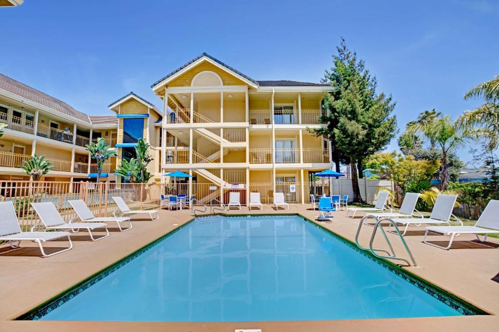 a pool in front of a hotel with chairs and a building at Hotel Solares in Santa Cruz