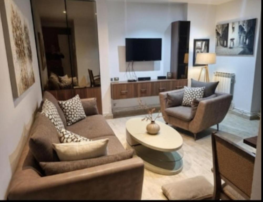 a living room with two couches and a tv at Appartement familial centre de Hydra in Hydra
