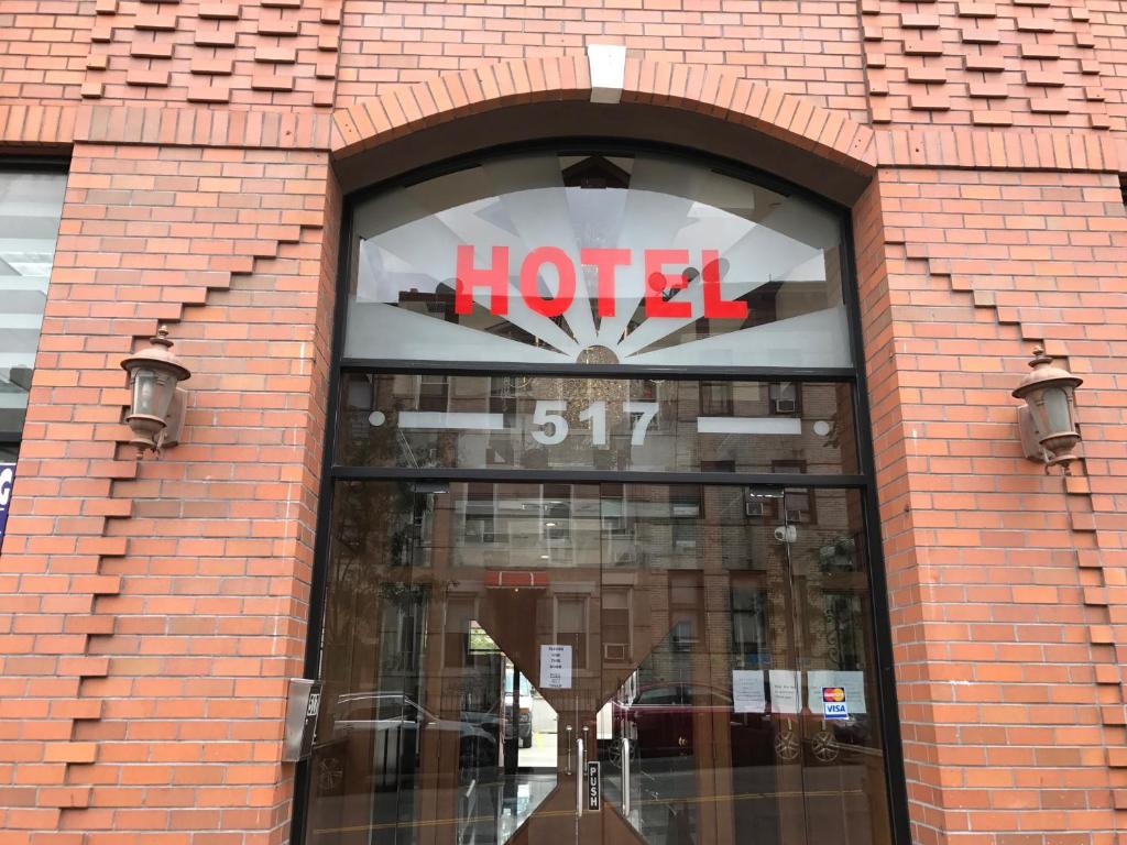 a hotel sign in the window of a brick building at Phoenix Hotel Brooklyn Sunset Park in Brooklyn