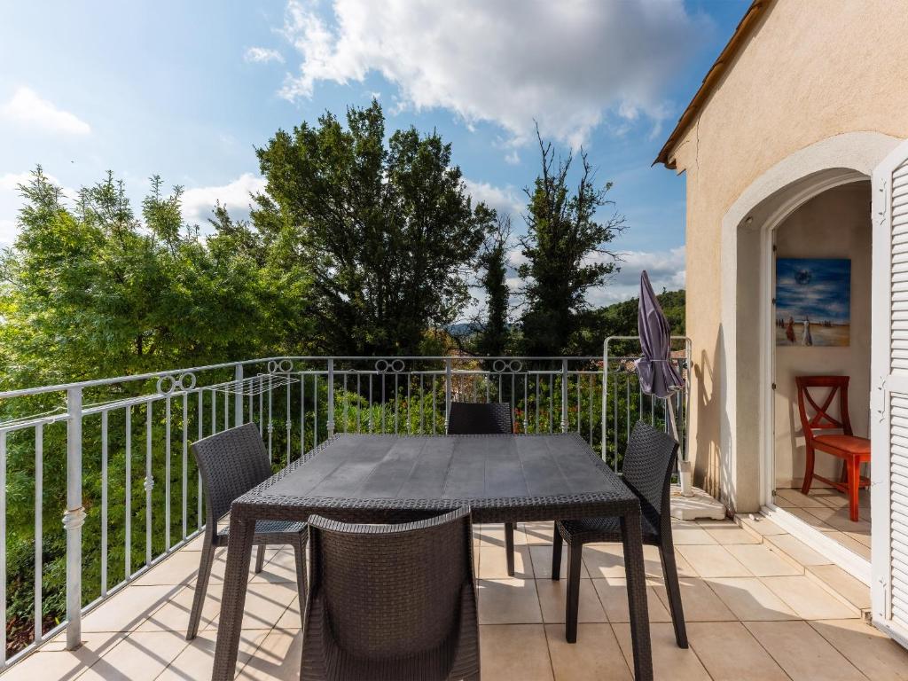 een terras met een tafel en stoelen op een balkon bij D de Camiole M N105 4P8 in Callian