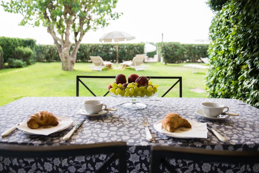 a table with two plates of food and a bowl of fruit at Jesolo sea front garden apartment in Lido di Jesolo