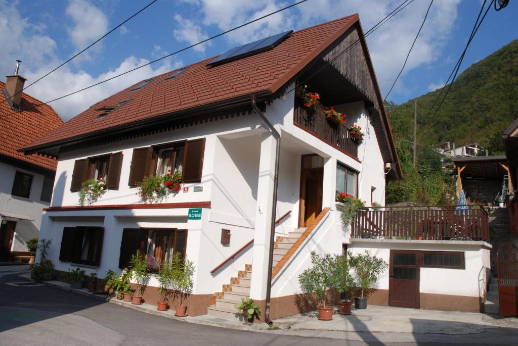 een wit huis met een rood dak bij Apartment Vito in Bovec