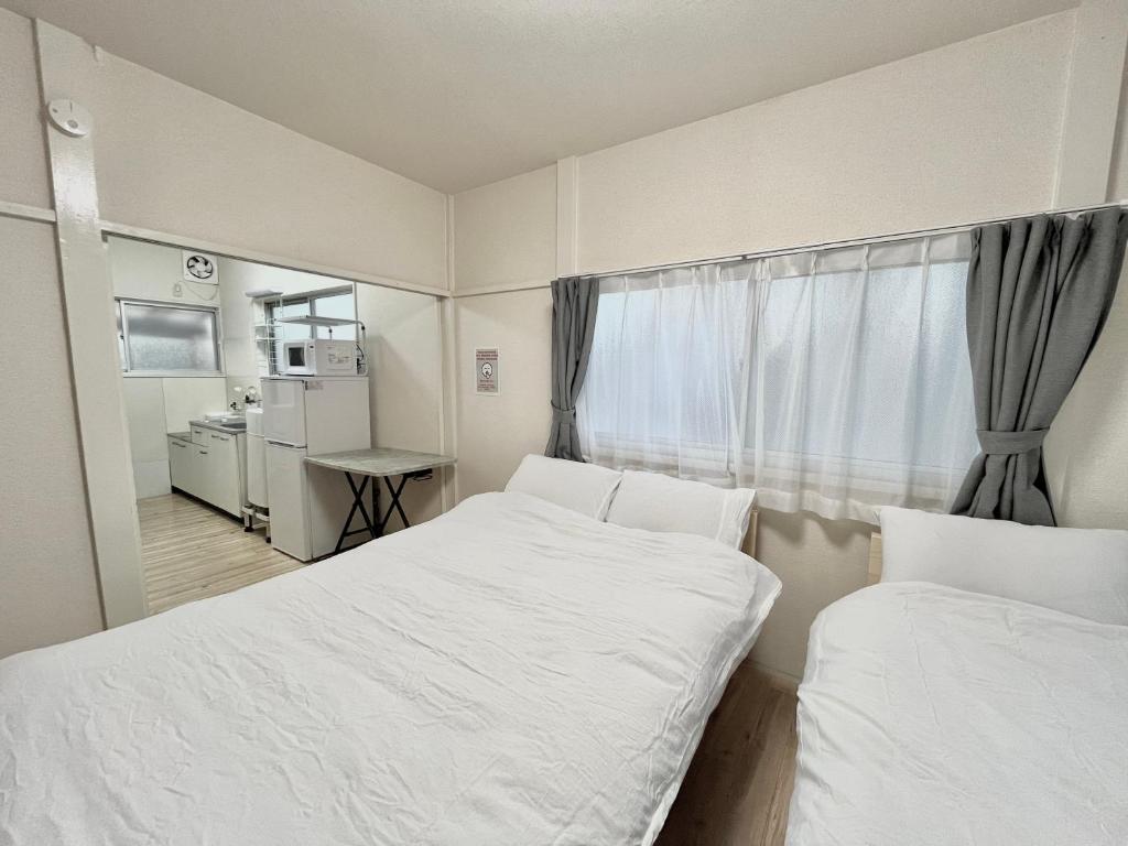 een kleine kamer met twee bedden en een raam bij tkm北小岩1丁目203 in Tokyo