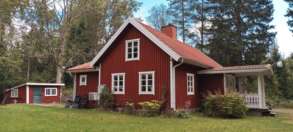 a red house with white windows in a yard at Lilla Skogstorp in Åseda