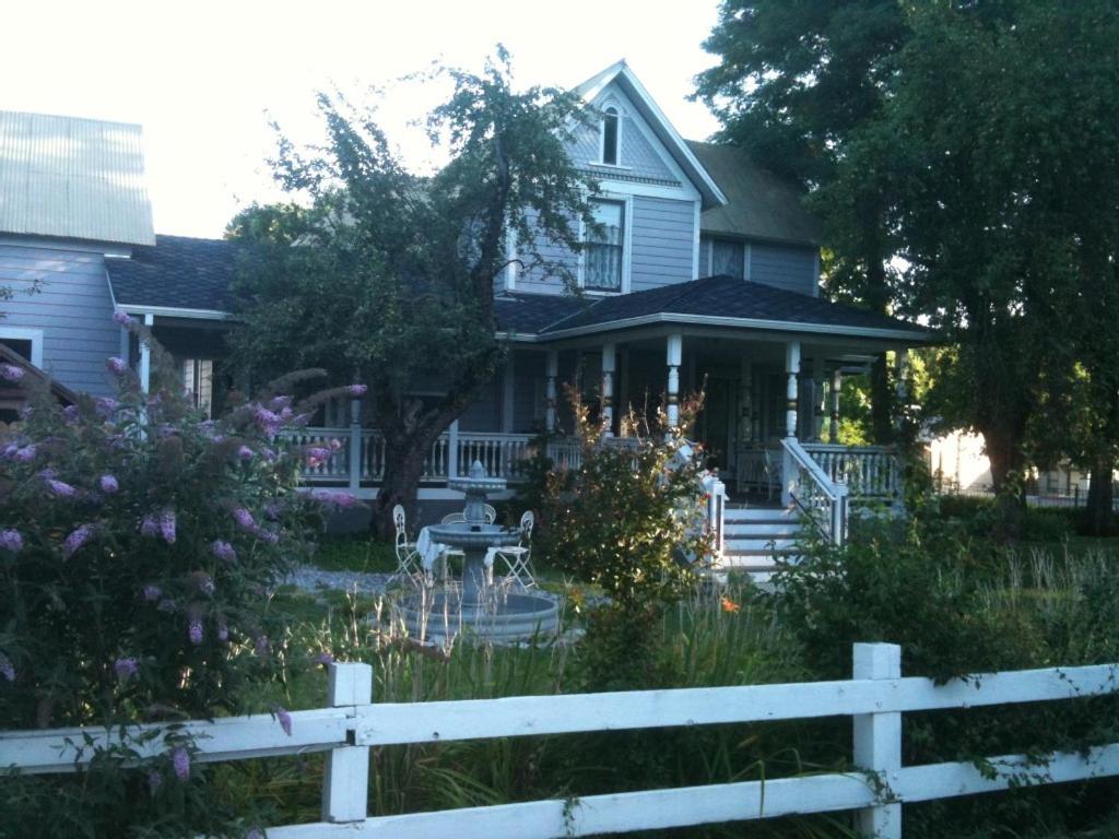 una cerca blanca frente a una casa en The Whitmore Inn, en Weaverville
